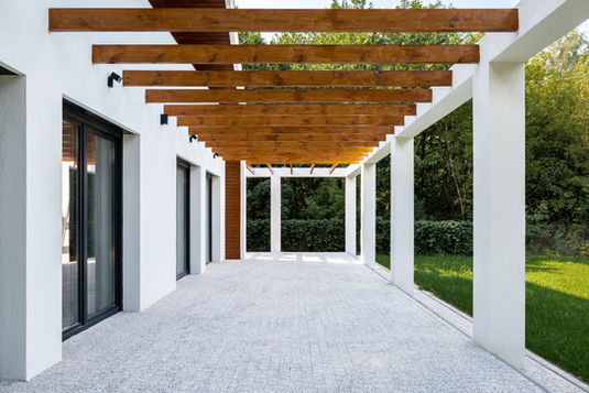 a white house with a wooden pergola over it