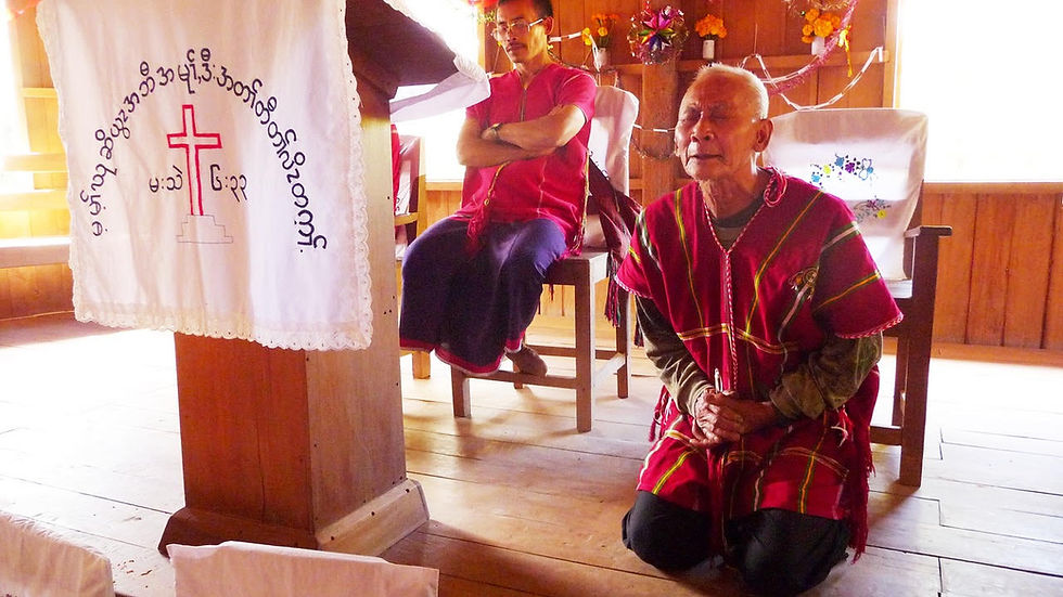 A Karen church leader humbly praying to God.