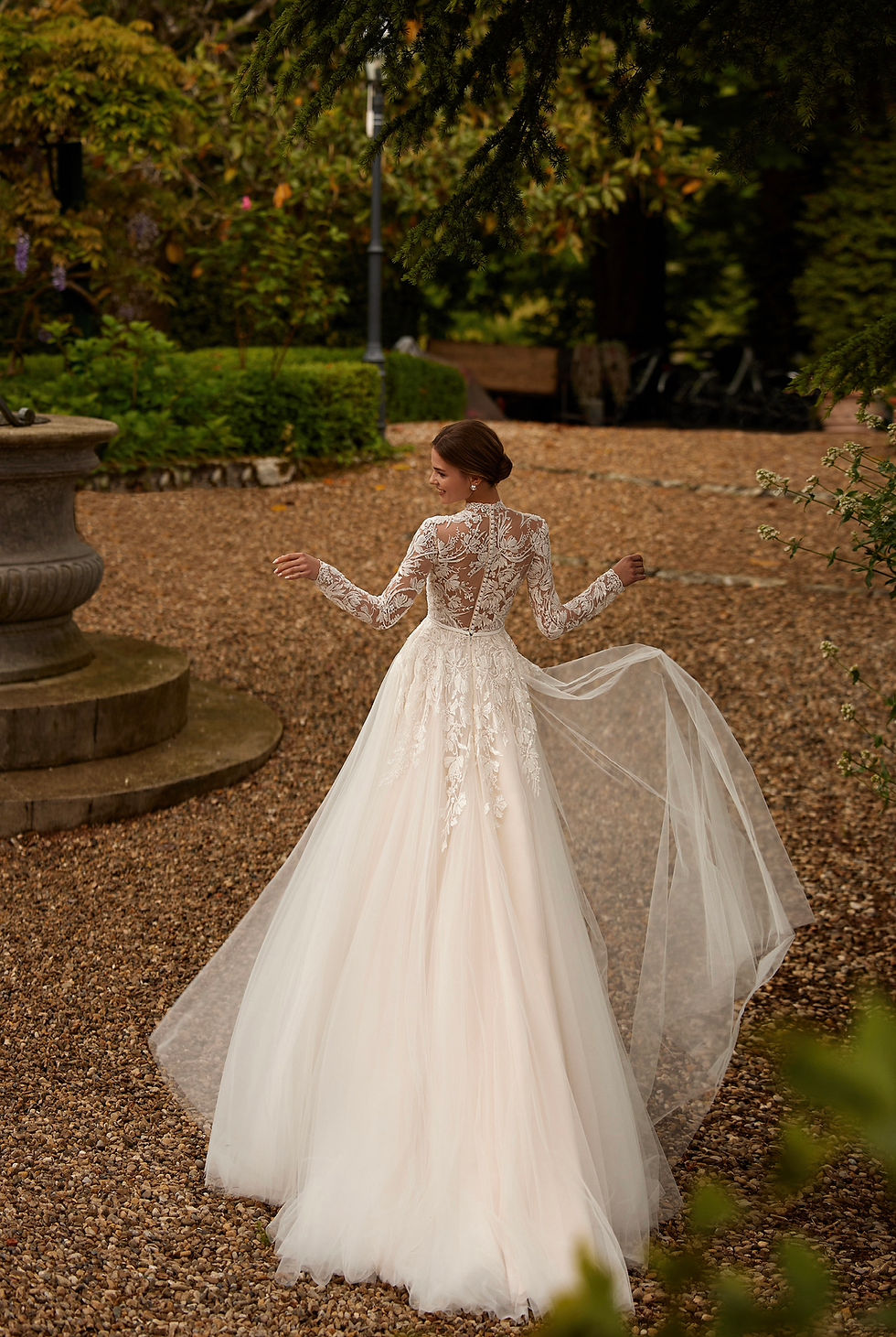 Thumbnail: Bride in a wedding dress featuring a modest neckline with a flowing veil.