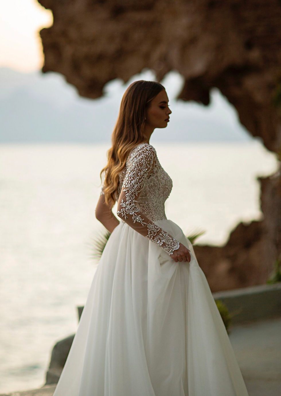 Thumbnail: Bride wearing a romantic wedding gown with delicate lace details and a flowing train.