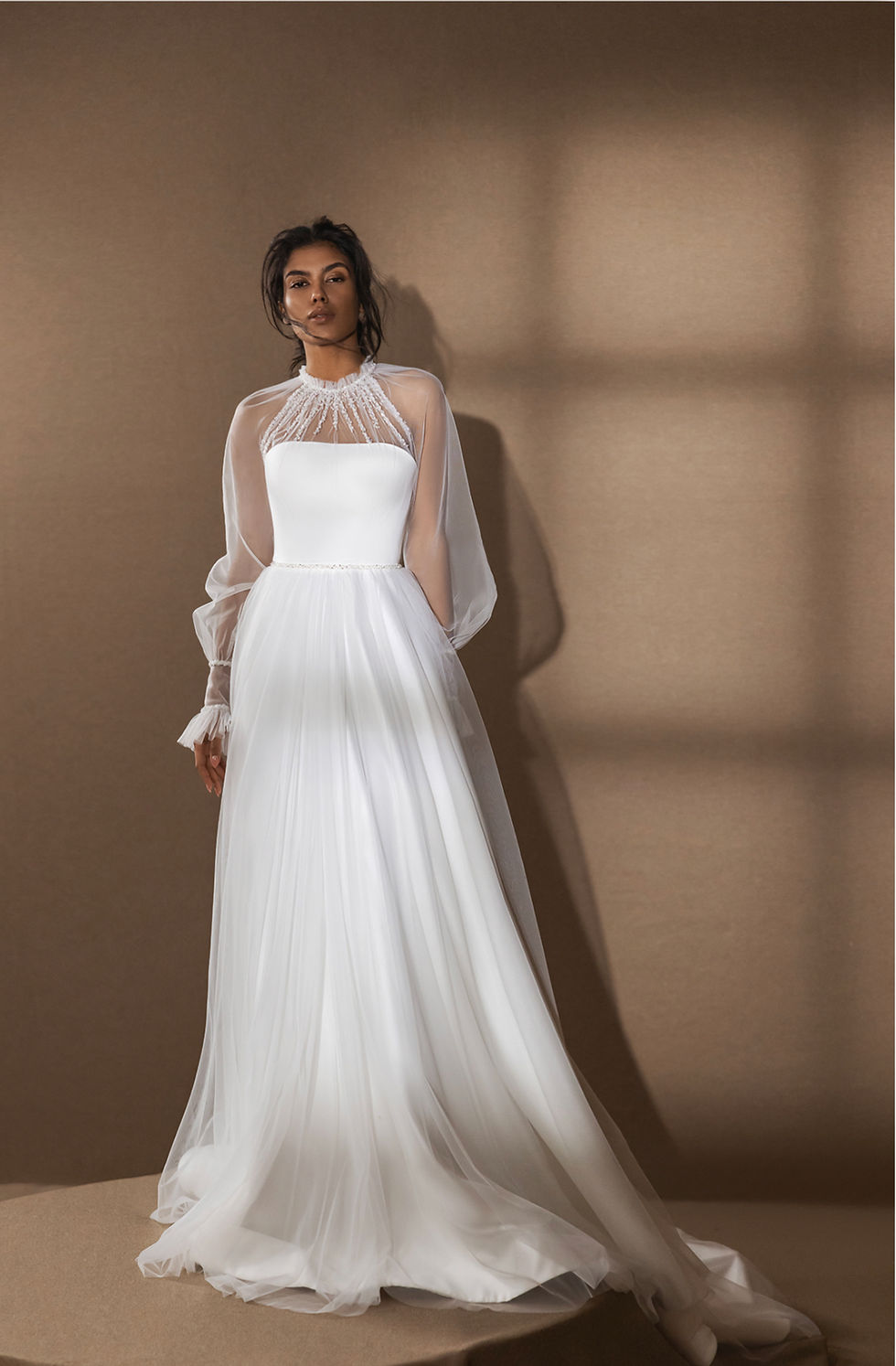 Thumbnail: This modest A-line wedding dress features a delicate chiffon skirt