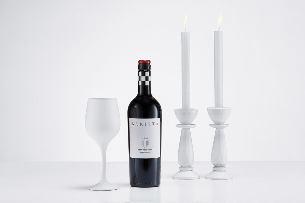 a bottle of barista pinot noir sits next to two white wine glasses
