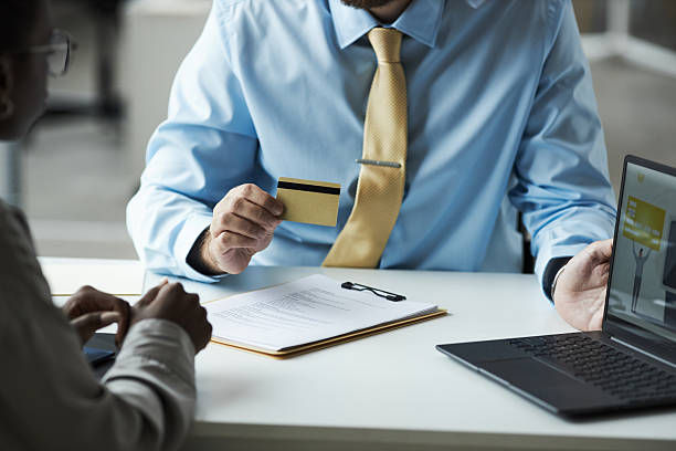 Two individuals seated at a table with a laptop and credit card, focused on Payment Removal Services.
