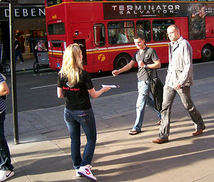a woman handing out leaflets in the stre