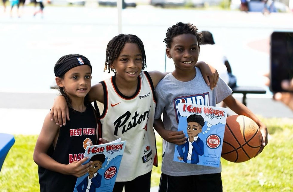 Three young kids smile for the camera while holding copies of the illustrated book I Can Work in Sports during the Neighbors Program Park Takeover event, showing excitement for learning and basketball.