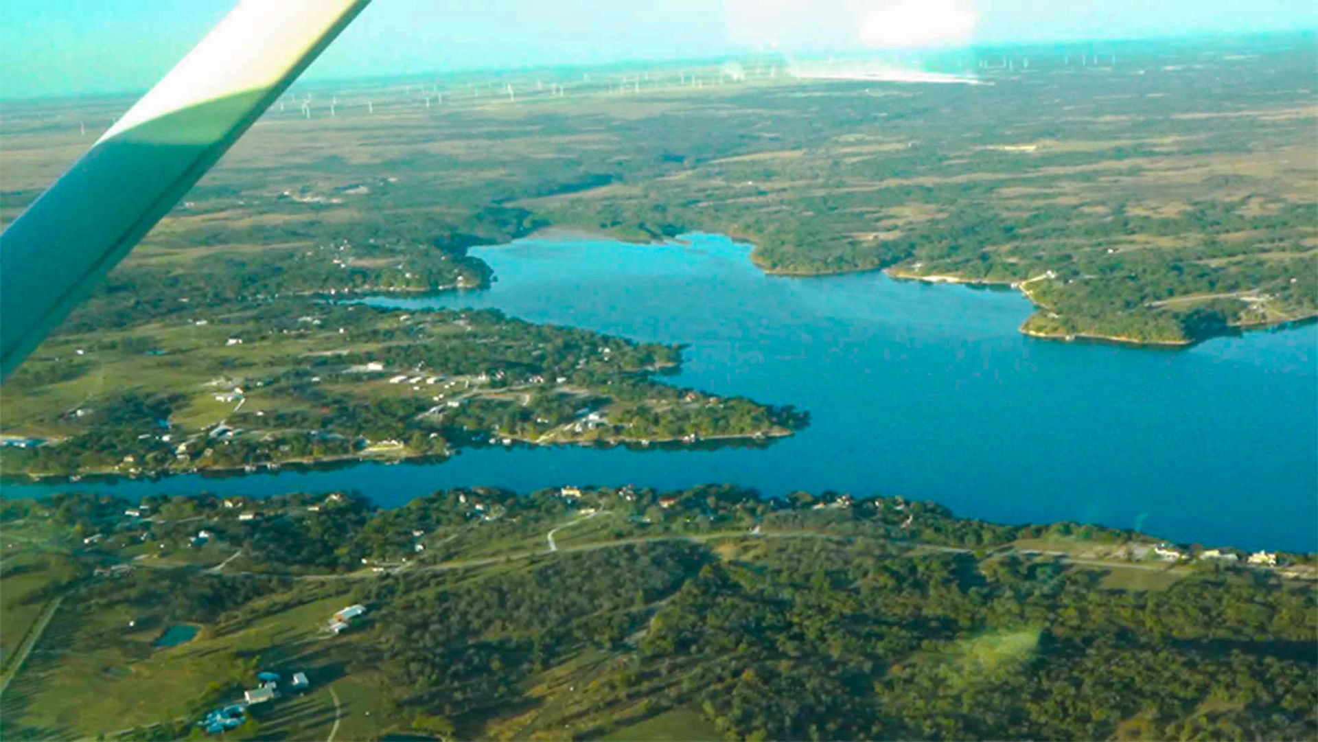 Cori flies over a lake before heading back to the airport to land her plane.