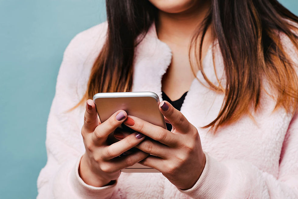 Teen looking down at her smartphone.
