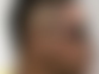 A man seated in a barber chair, preparing for a haircut to maintain his style between appointments