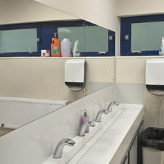 Clean commercial restroom with multiple sinks and mirrors.