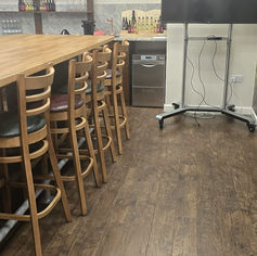 Clean wooden bar table with chairs in a dining area.
