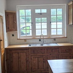 Clean wooden kitchen interior with a sink and large window