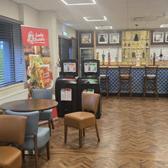 Clean bar area with parquet flooring and seating.