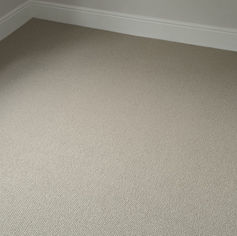 Clean beige carpet in a room with white baseboards.