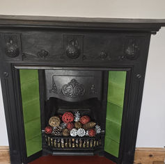 Clean black Victorian fireplace with green tiling.