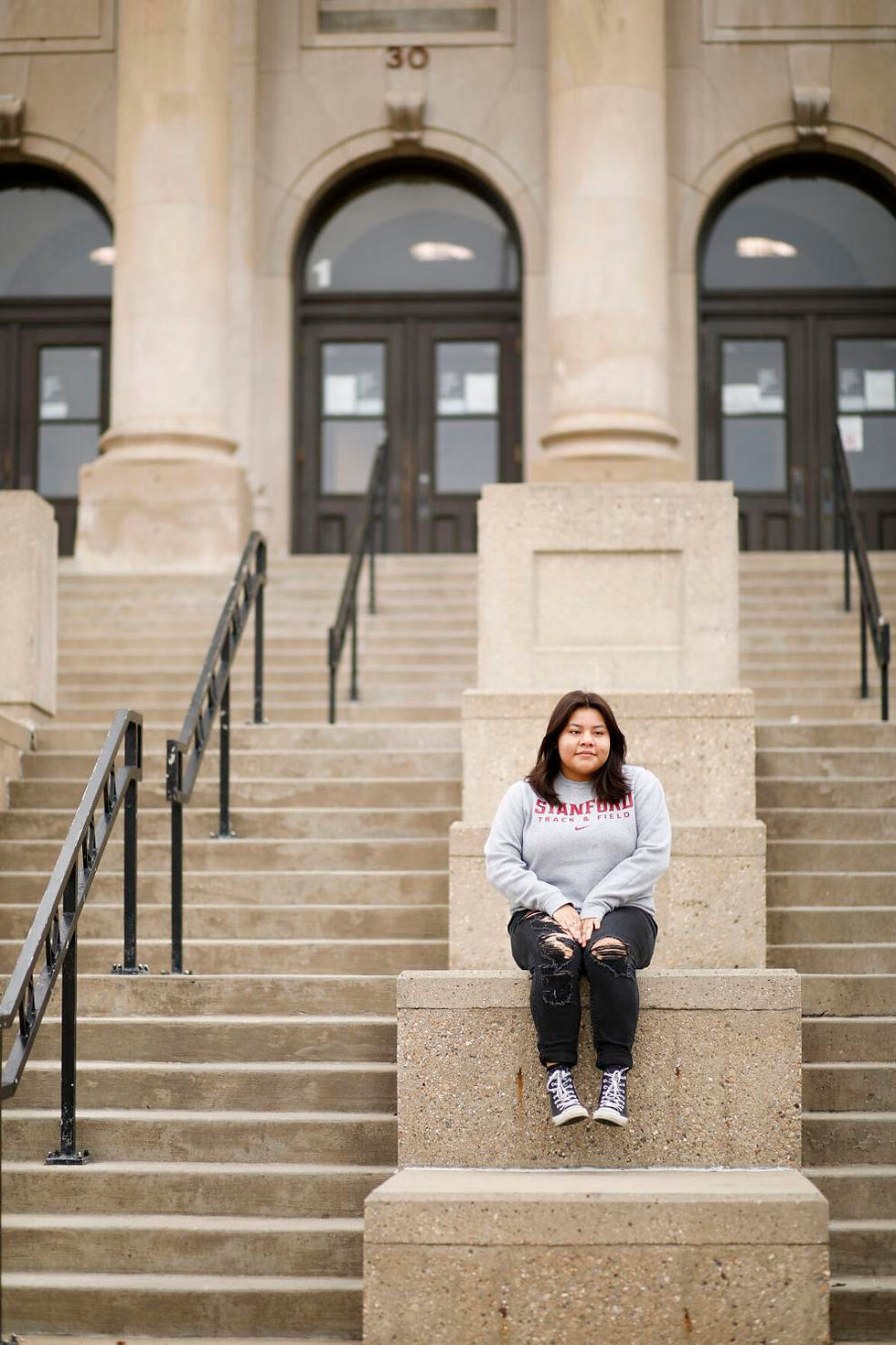 Student sitting on stairs outside building