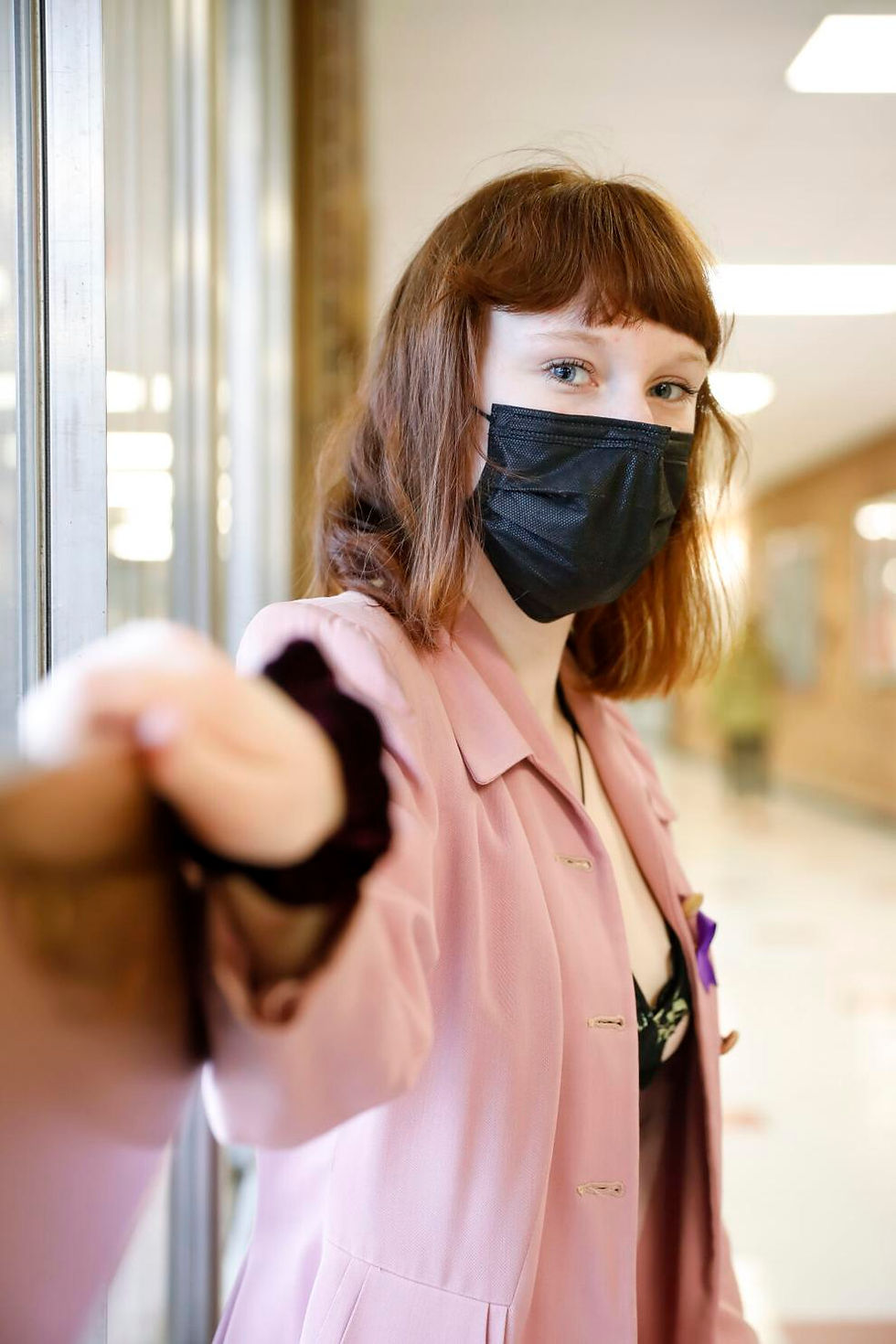 Student wearing a mask with arm extended