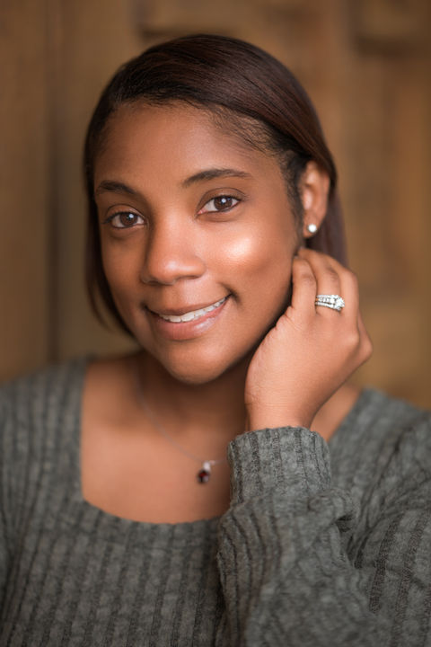 Smiling woman with dark hair and a ring