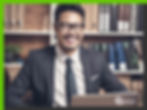 Happy Asian businessman in front of his laptop smiling.