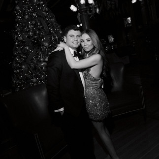 bride and groom smile in front of a christmas tree in the lobby of larchmont yacht club