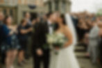 bride and groom kiss surrounded by family after their ceremony
