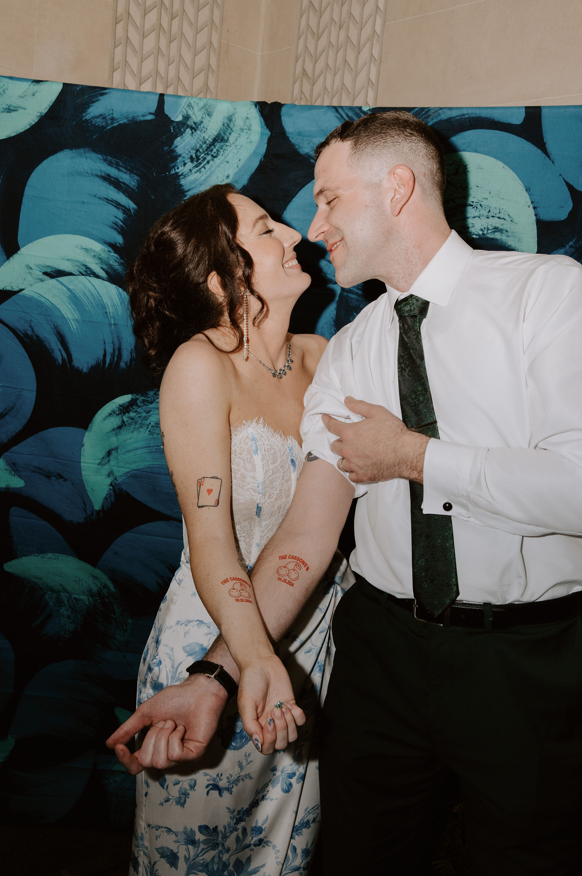 couple kiss after doing their custom temporary tattoo at their wedding 