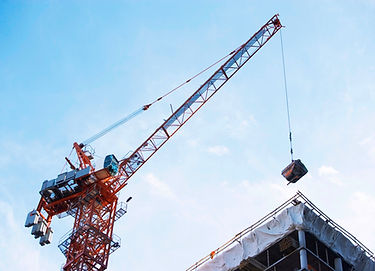 Crane holding a load in the process of enabling building construction.