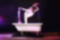 Artiste en contorsion créant des éclats de lumière avec ses mains lors d'une performance acrobatique.