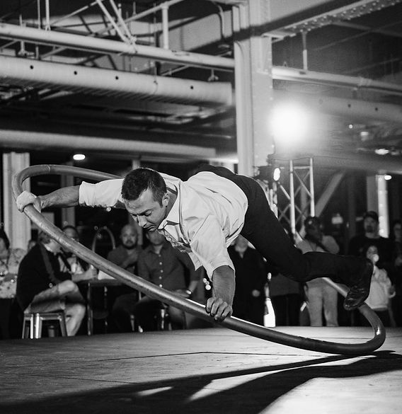 Artiste réalisant des acrobaties au sol sur une roue Cyr, une performance spectaculaire de cirque contemporain avec Prod.G