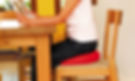 girl sitting on a red wobble cushion on a chair