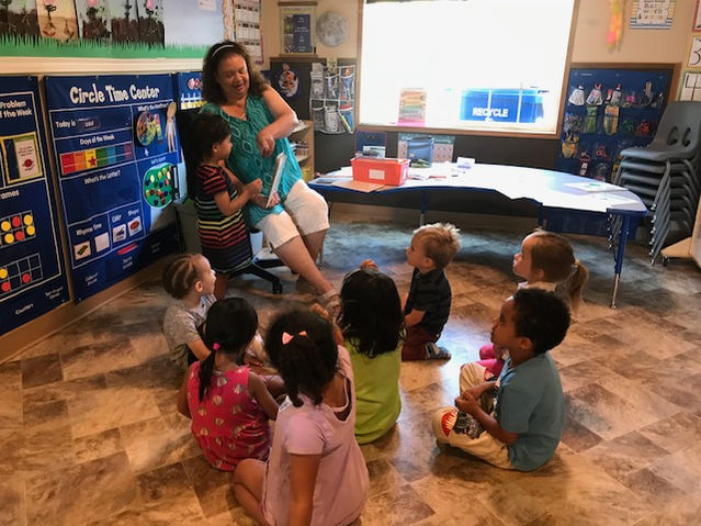 Children listening to story time with their teacher.