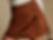 Close-up of a brown suede mini skirt with side buttons on a person in a white ribbed top against a beige background.