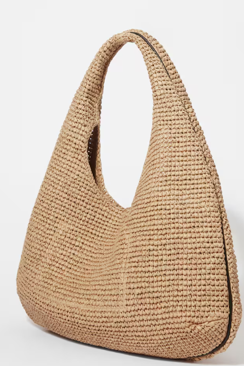 Beige woven straw tote bag with arched handle, shown on a plain white background.