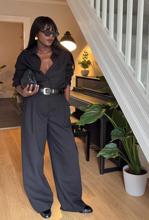 Powerful monochrome office look with black straight-leg tailored trousers, a tucked-in black button-down shirt, a black leather belt with a gold buckle, and a quilted clutch – 6 Spring Essentials