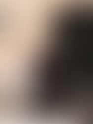 Woman wearing a polished grey maxi skirt styled with a long dark brown coat, black boots, and a minimal black top for a chic city outfit