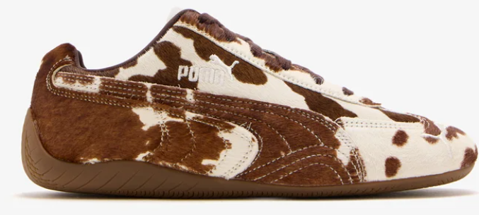 Brown and white cow-print Puma sneaker in side view on a white background, with visible Puma logo.