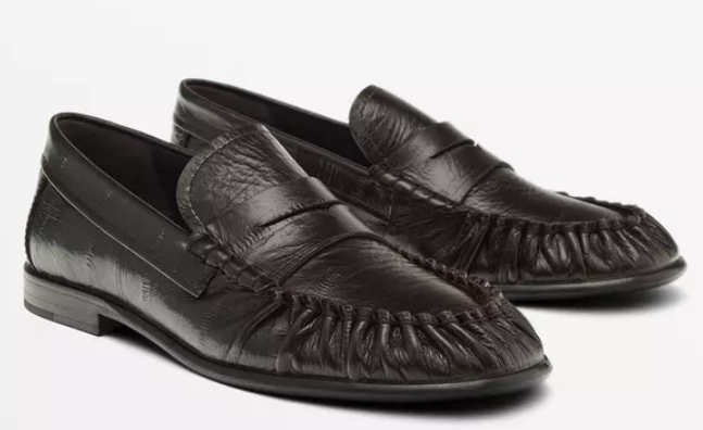 Pair of black leather loafers on a white background, shown side by side with a polished, classic look.