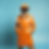 Retro-humanoid robot in disguise and wearing a burnt orange trench coat, orange hat, and glasses.