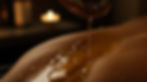 Tantric lingam massage - closeup of warm oil being poured onto a persons back
