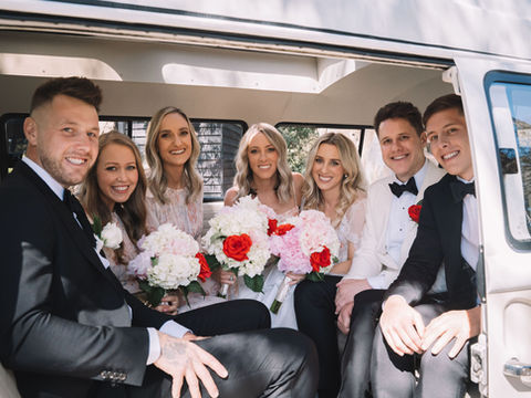 Bridal party seated inside kombi van smiling