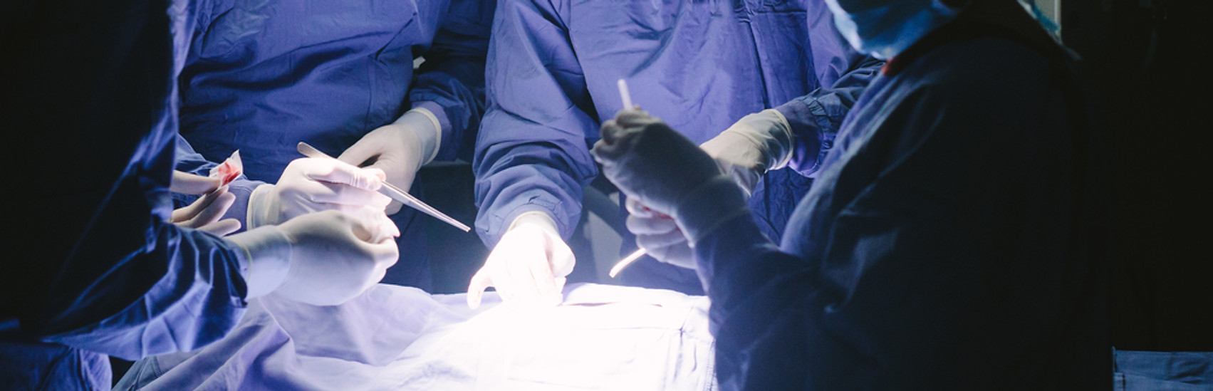 Team of professional surgeons performing surgery in operation room. Group of surgeon at w