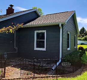 Gray house with a window and brown roof