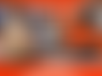 Employée de Pressing Chronopress à Ouagadougou remettant des uniformes propres et emballés à un client en tenue professionnelle, comptoir orange, portant un polo Chronopress, arrière-plan avec vêtements suspendus.