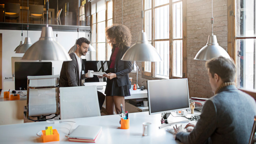 Ufficio moderno di una web agency con il team che collabora ai computer, rappresentando come spesso le agenzie gestiscono i domini per i clienti.