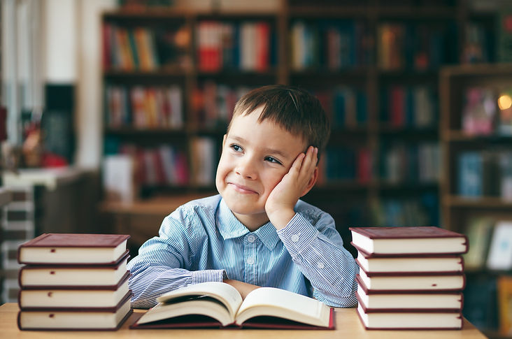 Single%20dreaming%20boy%20at%20the%20desk%20in%20the%20library%20enjoy%20books.%20Front%20