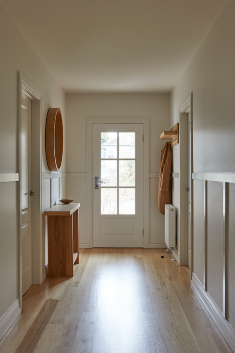 Light-filled entry with shaker style entry door and hardwood timber floors