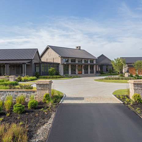 Exterior view of brick and stone custom, luxury mansion with landscaping, driveway