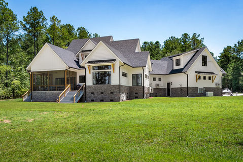 White House with hardie siding, stone veneer, and shingle roof at the lake, screen porch