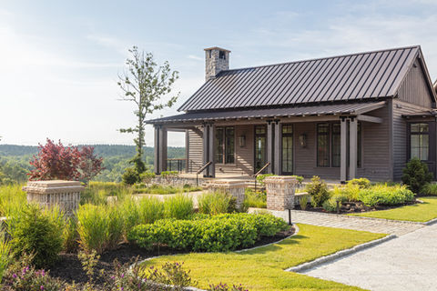 Exterior view of brick and stone custom, luxury mansion with landscaping