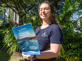 A person reads a brochure titled Waterways Report Card 2025