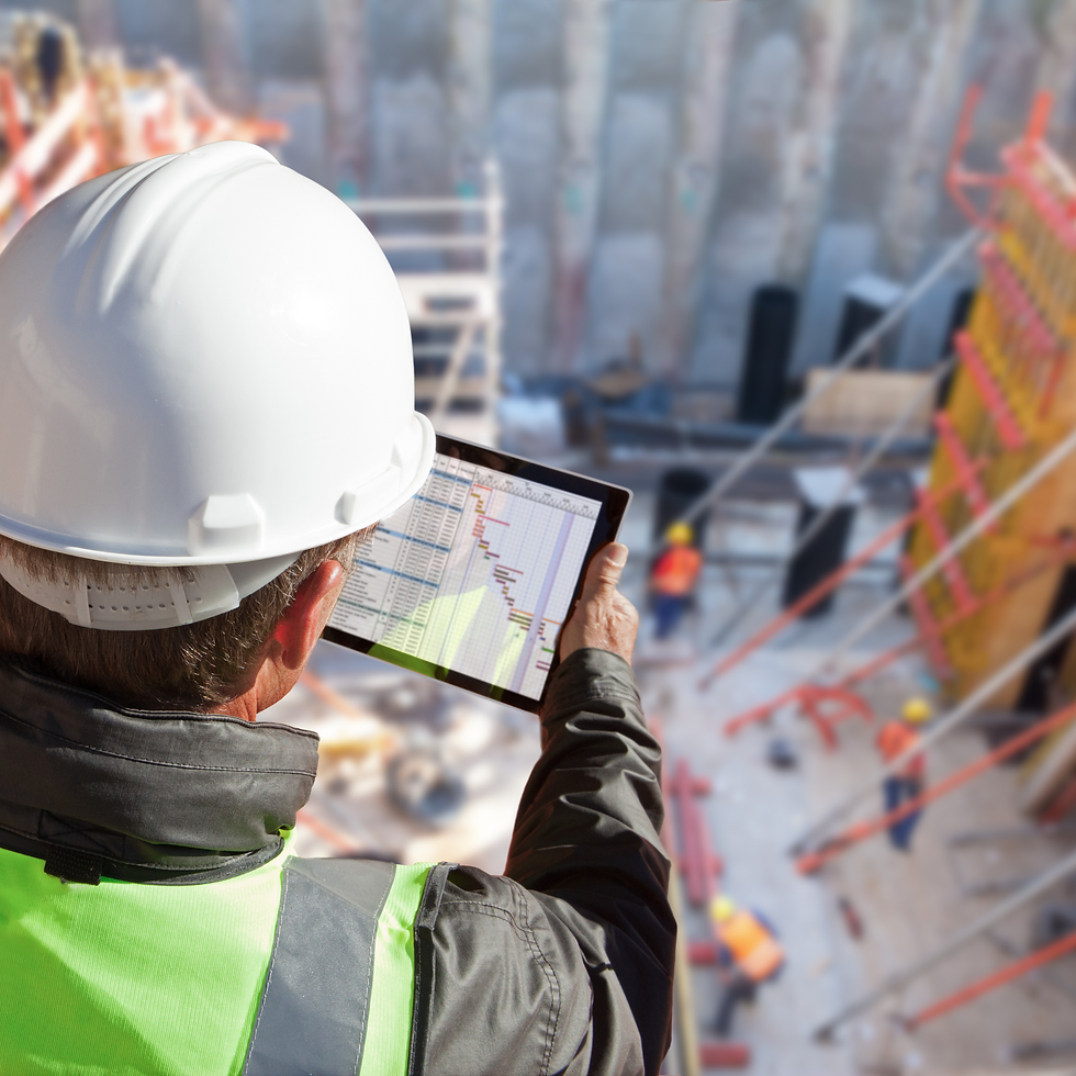 Bauleiter auf einer Baustelle prüft mit Tablet Baupläne und Projektfortschritt im Hochbau